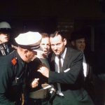Police officers lead Lee Harvey Oswald.